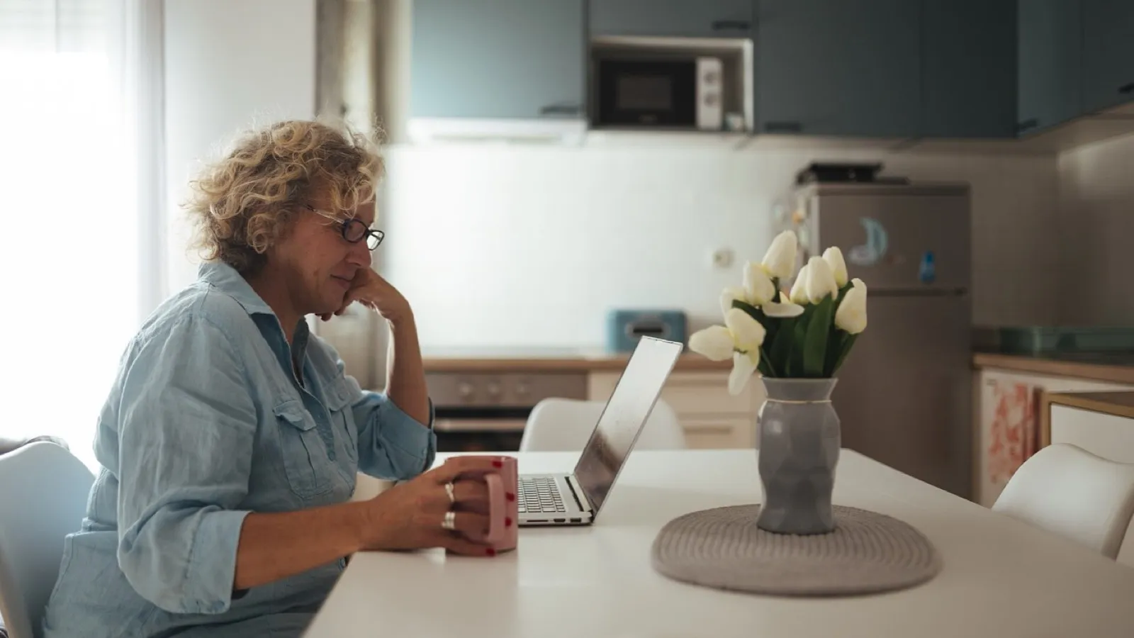 A laptop on a table at home, where nobody is in the room.